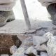 man breaking up a concrete slab with a jackhammer