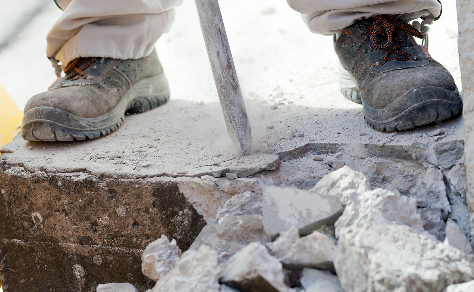 man breaking up a concrete slab with a jackhammer